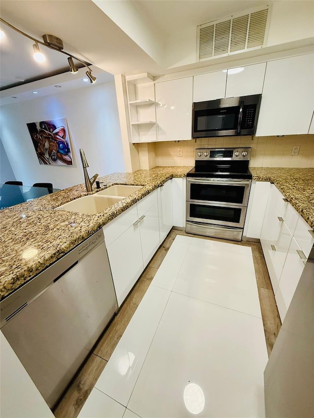 3800 N Hills Dr Unit 312, Hollywood, FL 33021 - kitchen with appliances with stainless steel finishes, white cabinets, light stone counters, and open shelves