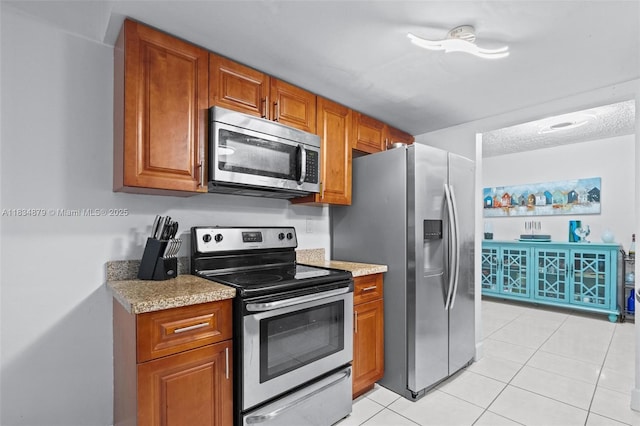 4803 NW 47th Ter, Tamarac, FL 33319 - kitchen featuring appliances with stainless steel finishes, brown cabinetry, and light tile patterned flooring