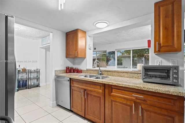 4803 NW 47th Ter, Tamarac, FL 33319 - kitchen featuring stainless steel appliances, light tile patterned floors, brown cabinets, light stone counters, and a textured ceiling