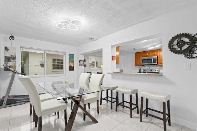 4803 NW 47th Ter, Tamarac, FL 33319 - dining room featuring a textured ceiling and light tile patterned floors