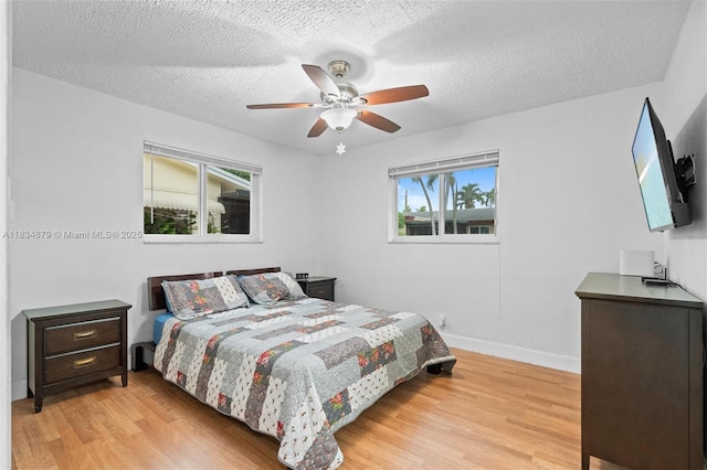 4803 NW 47th Ter, Tamarac, FL 33319 - bedroom featuring light wood-style floors, a textured ceiling, and a ceiling fan