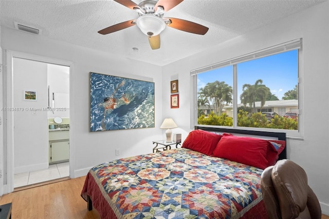 4803 NW 47th Ter, Tamarac, FL 33319 - bedroom with wood finished floors, a textured ceiling, a ceiling fan, and ensuite bath