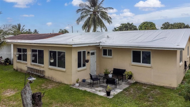 4803 NW 47th Ter, Tamarac, FL 33319 - rear view of house with stucco siding, a patio, and a lawn