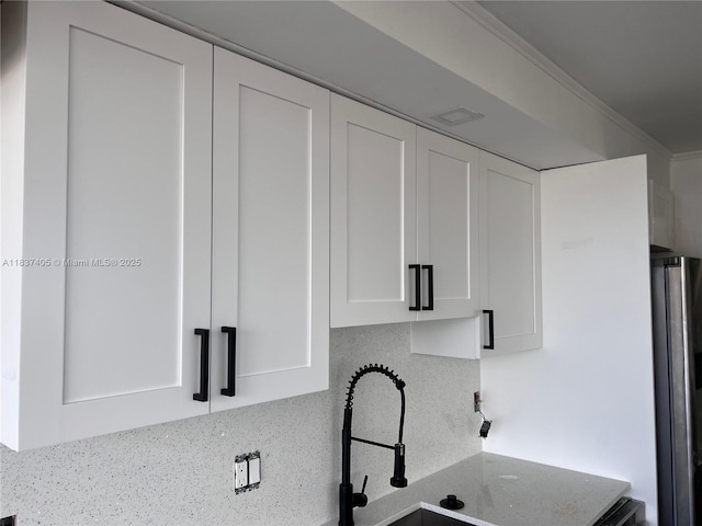 9850 Hammocks Blvd Unit 107, Miami, FL 33196 - kitchen featuring freestanding refrigerator, white cabinetry, backsplash, and stone counters