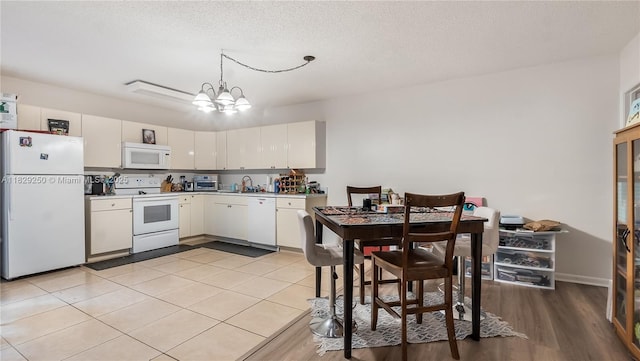 9111 SW 22nd Ct Unit B-3, Davie, FL 33324 - kitchen featuring white appliances, a chandelier, white cabinetry, pendant lighting, and light countertops