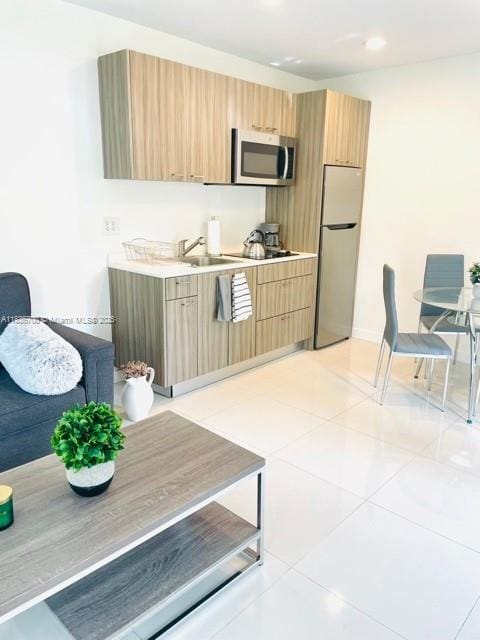 1419 W Ave Unit 106, Miami Beach, FL 33139 - kitchen with stainless steel microwave, freestanding refrigerator, light countertops, modern cabinets, and light tile patterned flooring