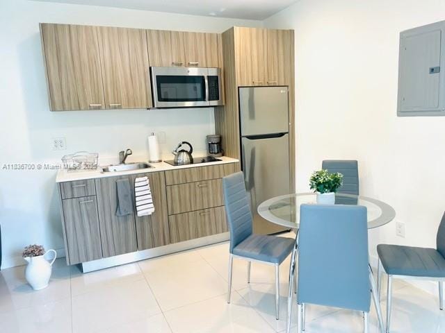 1419 W Ave Unit 106, Miami Beach, FL 33139 - kitchen with appliances with stainless steel finishes, electric panel, light countertops, modern cabinets, and light tile patterned floors
