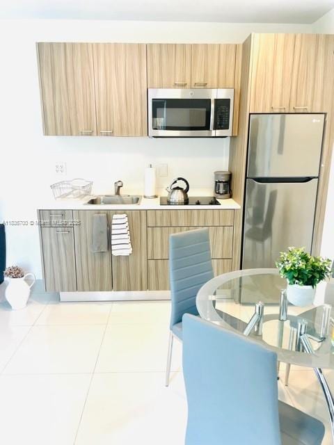 1419 W Ave Unit 106, Miami Beach, FL 33139 - kitchen with stainless steel appliances, modern cabinets, light brown cabinetry, and light countertops