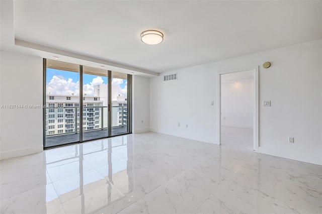 5701 Collins Ave Unit 1611, Miami Beach, FL 33140 - spare room featuring floor to ceiling windows, marble finish floors, and a smoke detector