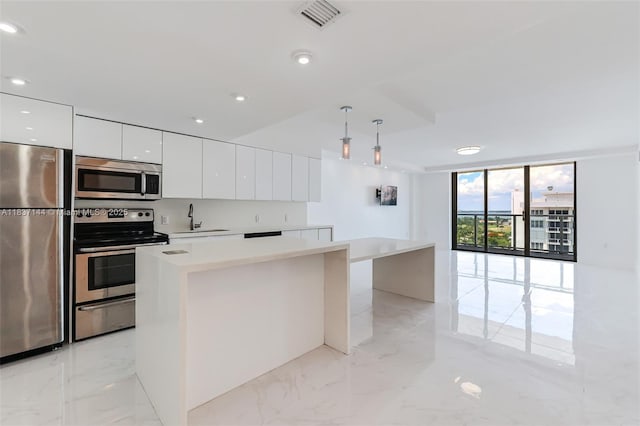 5701 Collins Ave Unit 1611, Miami Beach, FL 33140 - kitchen with appliances with stainless steel finishes, modern cabinets, white cabinets, light marble finish floors, and light countertops