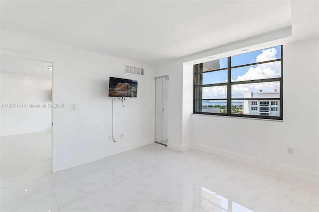 5701 Collins Ave Unit 1611, Miami Beach, FL 33140 - unfurnished room featuring baseboards and light marble finish flooring