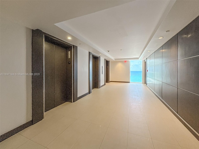 5701 Collins Ave Unit 1611, Miami Beach, FL 33140 - hallway featuring elevator, recessed lighting, a raised ceiling, and light floors