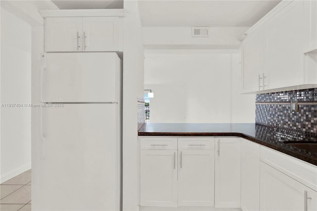1990 W 56th St Unit 1407, Hialeah, FL 33012 - kitchen featuring freestanding refrigerator, tasteful backsplash, white cabinetry, and dark countertops