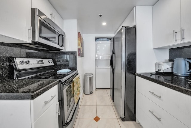 1717 N Bayshore Dr Unit A-3237, Miami, FL 33132 - kitchen featuring appliances with stainless steel finishes, stacked washer and clothes dryer, white cabinets, tasteful backsplash, and light tile patterned floors