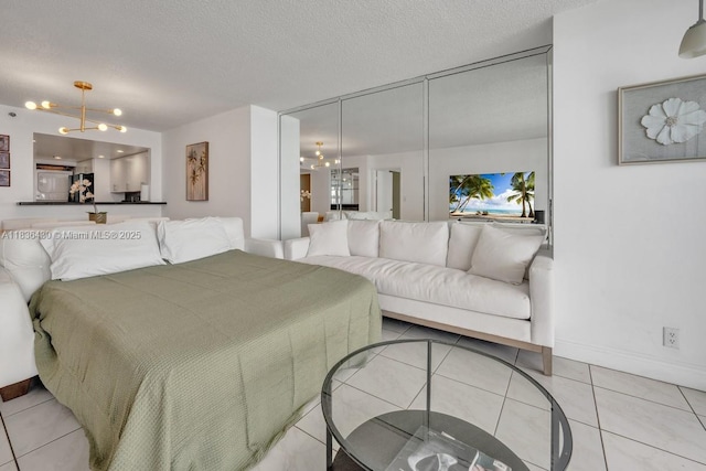 1717 N Bayshore Dr Unit A-3237, Miami, FL 33132 - bedroom with a chandelier, tile patterned flooring, freestanding refrigerator, ensuite bathroom, and a textured ceiling