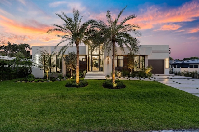 416 NW 24th St, Wilton Manors, FL 33311 - view of front of home featuring a garage, driveway, stucco siding, and a yard