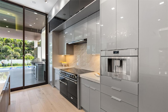 416 NW 24th St, Wilton Manors, FL 33311 - kitchen with modern cabinets, oven, tasteful backsplash, and expansive windows