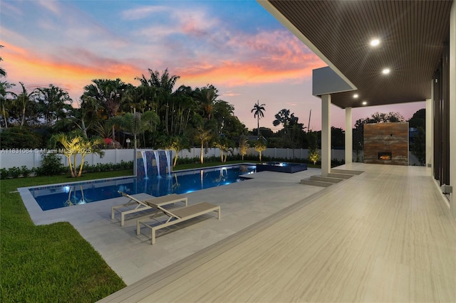 416 NW 24th St, Wilton Manors, FL 33311 - view of swimming pool with an outdoor stone fireplace, a patio, and a fenced backyard