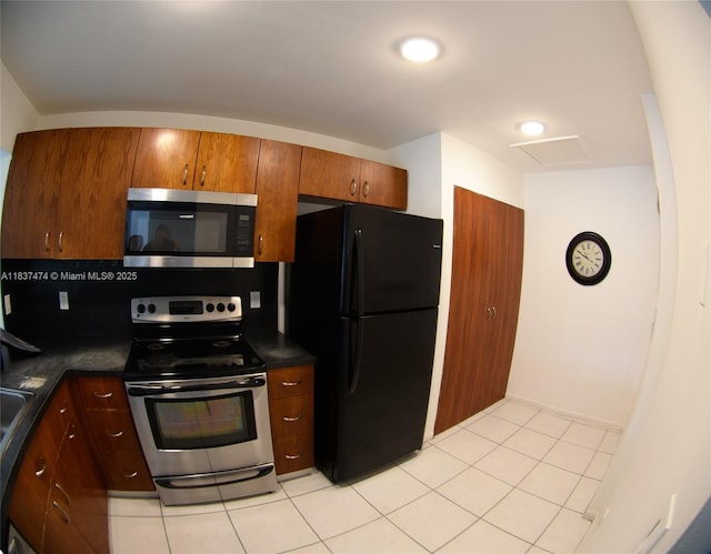 20825 NE 8th Ct Unit 203-19, Miami, FL 33179 - kitchen with appliances with stainless steel finishes, dark countertops, light tile patterned floors, and brown cabinets