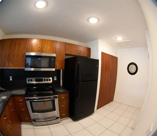 20825 NE 8th Ct Unit 203-19, Miami, FL 33179 - kitchen with stainless steel appliances, dark countertops, light tile patterned floors, and brown cabinetry