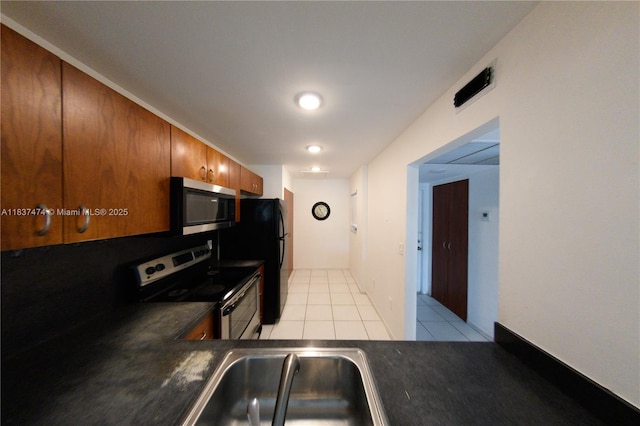 20825 NE 8th Ct Unit 203-19, Miami, FL 33179 - kitchen with appliances with stainless steel finishes, dark countertops, brown cabinets, and light tile patterned floors