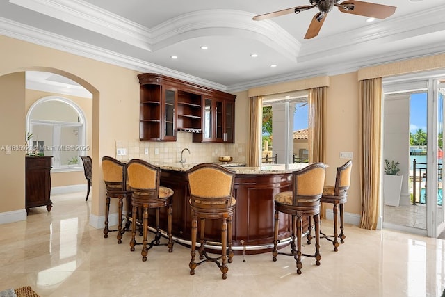 66 S Hibiscus Dr, Miami Beach, FL 33139 - dining space featuring a tray ceiling, crown molding, arched walkways, a chandelier, and a water view