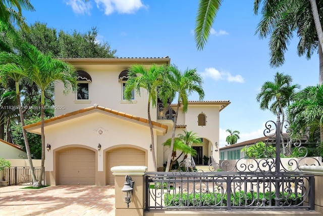 66 S Hibiscus Dr, Miami Beach, FL 33139 - mediterranean / spanish-style home featuring an attached garage, decorative driveway, stucco siding, and a balcony