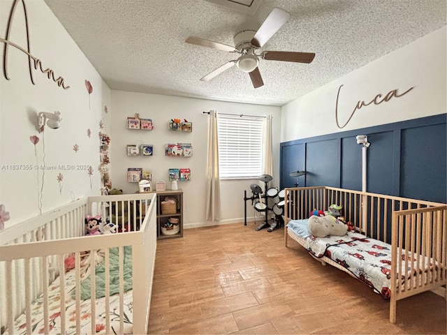 11236 SW 11th St, Pembroke Pines, FL 33025 - bedroom featuring a textured ceiling, light wood finished floors, a ceiling fan, and wainscoting
