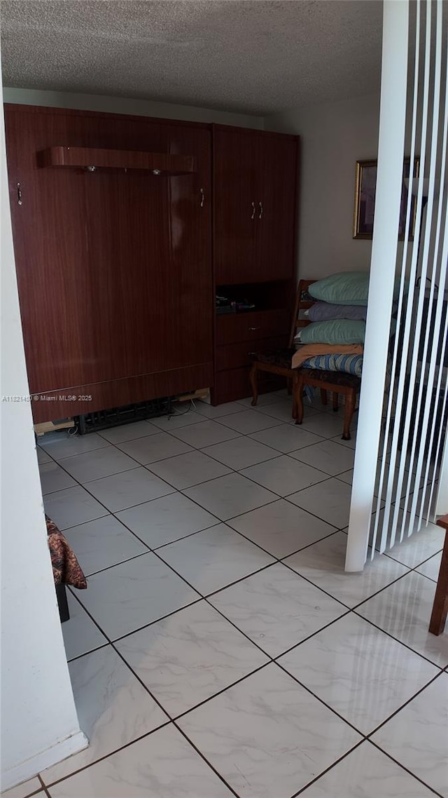 2899 Collins Ave Unit 821, Miami Beach, FL 33140 - hallway with a textured ceiling and light tile patterned floors