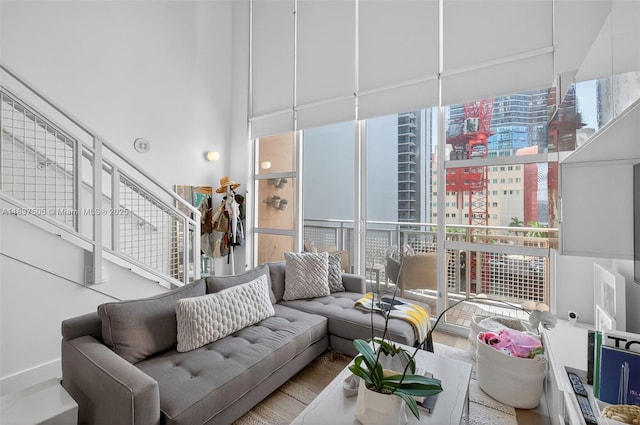 244 Biscayne Blvd Unit 446, Miami, FL 33132 - living room featuring expansive windows, a high ceiling, healthy amount of natural light, stairs, and wood finished floors