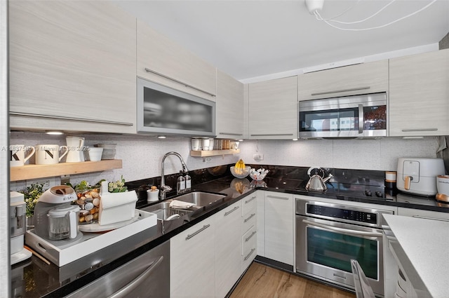 244 Biscayne Blvd Unit 446, Miami, FL 33132 - kitchen featuring appliances with stainless steel finishes, modern cabinets, wood finished floors, and dark stone countertops
