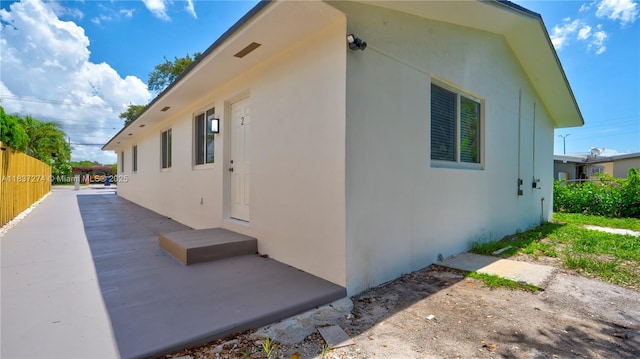 2820 NW 95th St, Miami, FL 33147 - view of side of property with stucco siding and a patio area