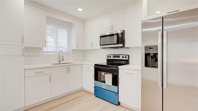 2820 NW 95th St, Miami, FL 33147 - kitchen with stainless steel appliances, light countertops, white cabinetry, light wood-type flooring, and recessed lighting