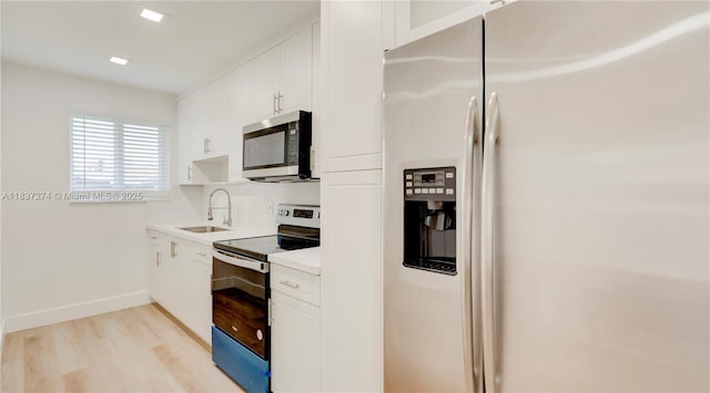 2820 NW 95th St, Miami, FL 33147 - kitchen featuring appliances with stainless steel finishes, light wood-style floors, white cabinetry, and light countertops
