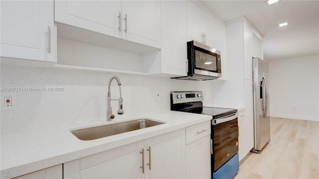2820 NW 95th St, Miami, FL 33147 - kitchen with appliances with stainless steel finishes, white cabinets, light wood finished floors, and open shelves