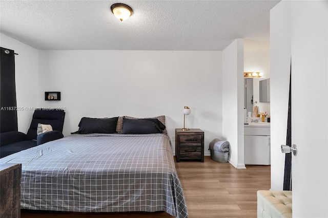 9730 Hammocks Blvd Unit 201-28, Miami, FL 33196 - bedroom featuring wood finished floors, a textured ceiling, and ensuite bathroom