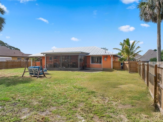 521 NE Dinner, Dinner, Palm Bay, FL 32907 - rear view of house with a sunroom, a fenced backyard, a metal roof, and a standing seam roof