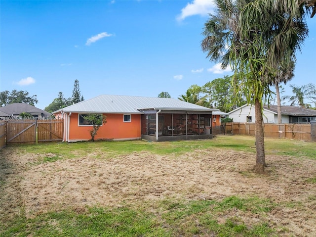 521 NE Dinner, Dinner, Palm Bay, FL 32907 - back of property with a sunroom, a metal roof, a fenced backyard, and a gate