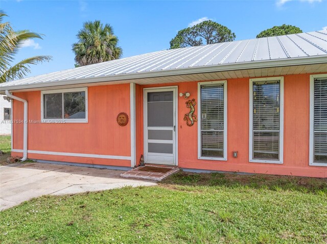 521 NE Dinner, Dinner, Palm Bay, FL 32907 - view of front facade featuring a front yard and a metal roof