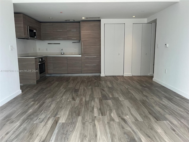 1300 S Miami Ave Unit 1207, Miami, FL 33130 - kitchen with stainless steel appliances, wood finished floors, modern cabinets, and light countertops