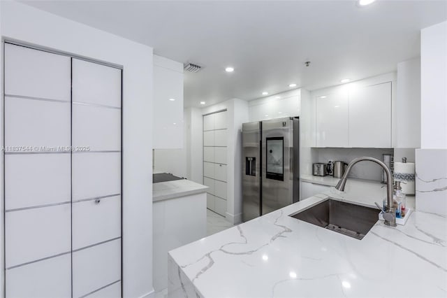 701 Brickell Key Blvd Unit 2011, Miami, FL 33131 - kitchen with stainless steel fridge with ice dispenser, modern cabinets, light marble finish flooring, white cabinets, and light stone countertops