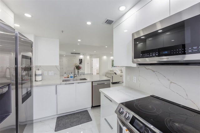701 Brickell Key Blvd Unit 2011, Miami, FL 33131 - kitchen featuring stainless steel appliances, white cabinets, modern cabinets, recessed lighting, and light stone countertops
