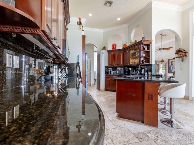 3043 Lakewood Dr, Weston, FL 33332 - kitchen with open shelves, arched walkways, ornamental molding, a breakfast bar area, and a ceiling fan