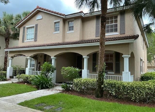 4603 Highgate Dr Unit C, Delray Beach, FL 33445 - mediterranean / spanish-style home with covered porch, stucco siding, and a tiled roof
