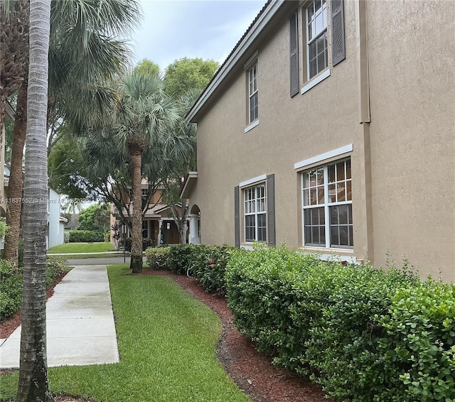 4603 Highgate Dr Unit C, Delray Beach, FL 33445 - view of property exterior with stucco siding and a lawn