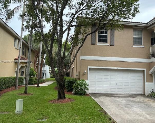 4603 Highgate Dr Unit C, Delray Beach, FL 33445 - view of front facade featuring stucco siding, concrete driveway, an attached garage, and a front yard