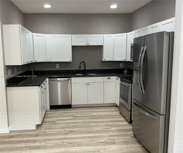 4603 Highgate Dr Unit C, Delray Beach, FL 33445 - kitchen featuring stainless steel appliances, dark countertops, recessed lighting, white cabinets, and light wood-type flooring