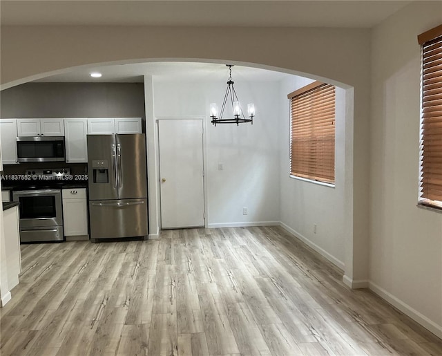 4603 Highgate Dr Unit C, Delray Beach, FL 33445 - kitchen with appliances with stainless steel finishes, dark countertops, light wood-style floors, and a chandelier