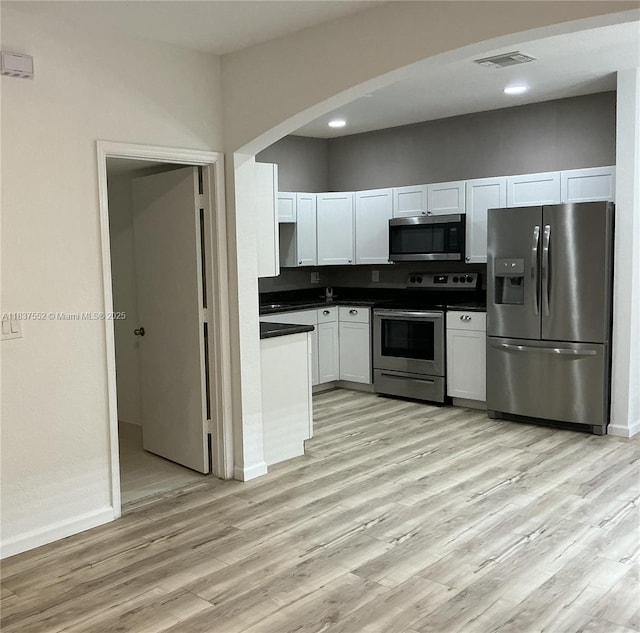 4603 Highgate Dr Unit C, Delray Beach, FL 33445 - kitchen with appliances with stainless steel finishes, dark countertops, light wood finished floors, white cabinets, and recessed lighting