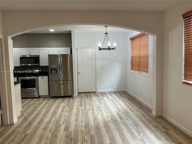 4603 Highgate Dr Unit C, Delray Beach, FL 33445 - kitchen with stainless steel appliances, dark countertops, a chandelier, and light wood-style flooring